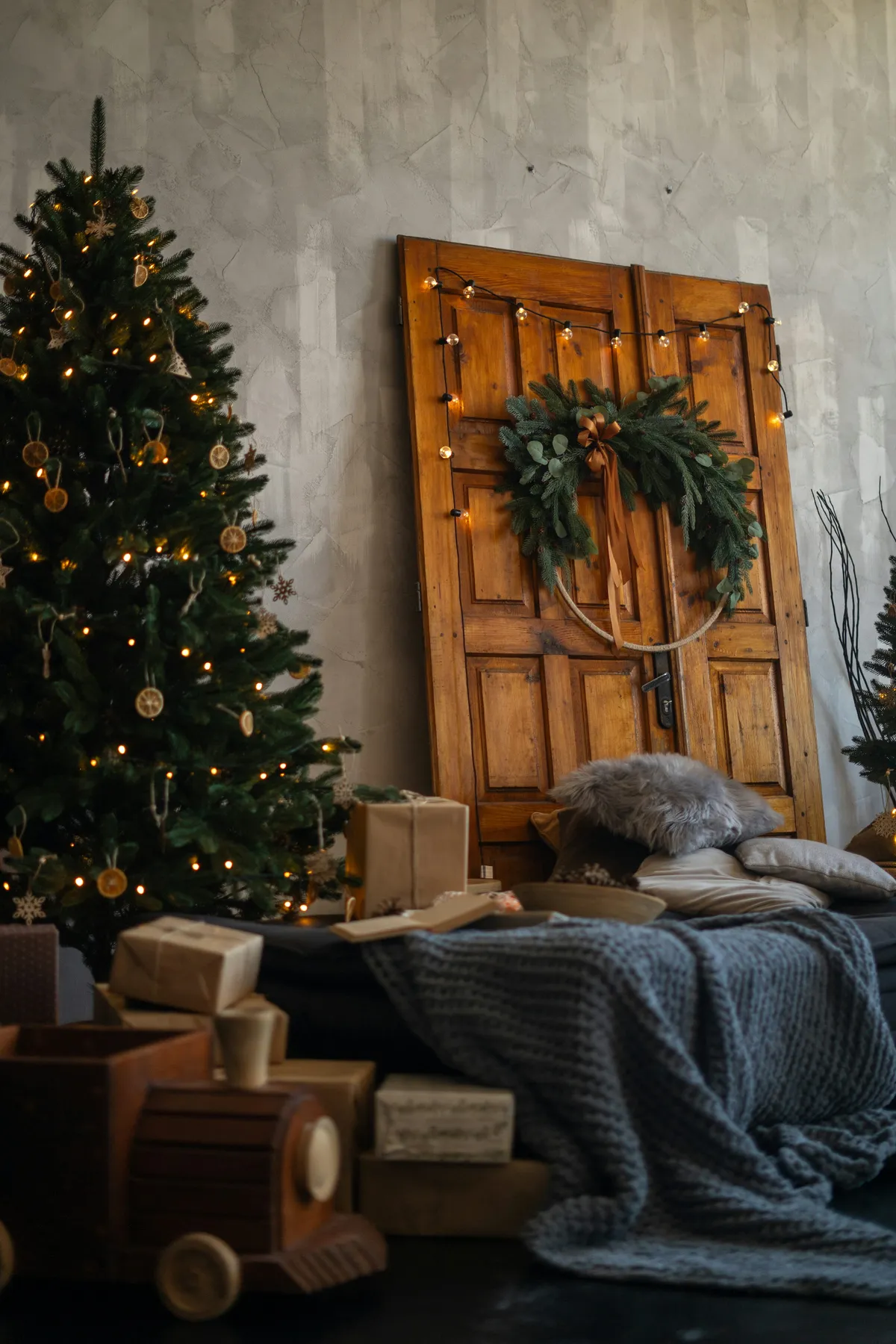A christmas tree and presents under a wooden door - Free Photo on Unsplash