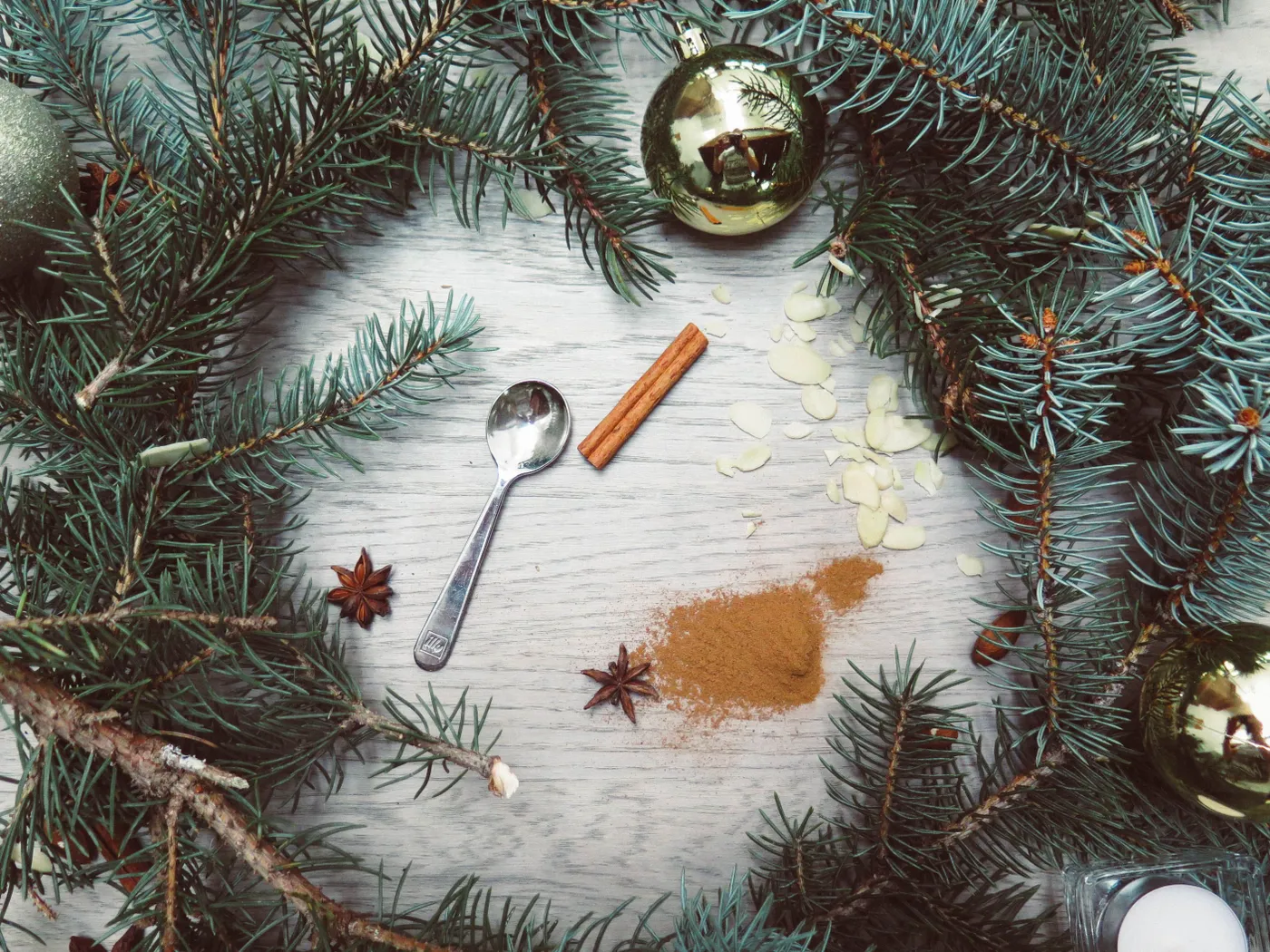 A Christmas wreath with spices and ornaments on a wooden background, capturing a cozy festive atmosphere.