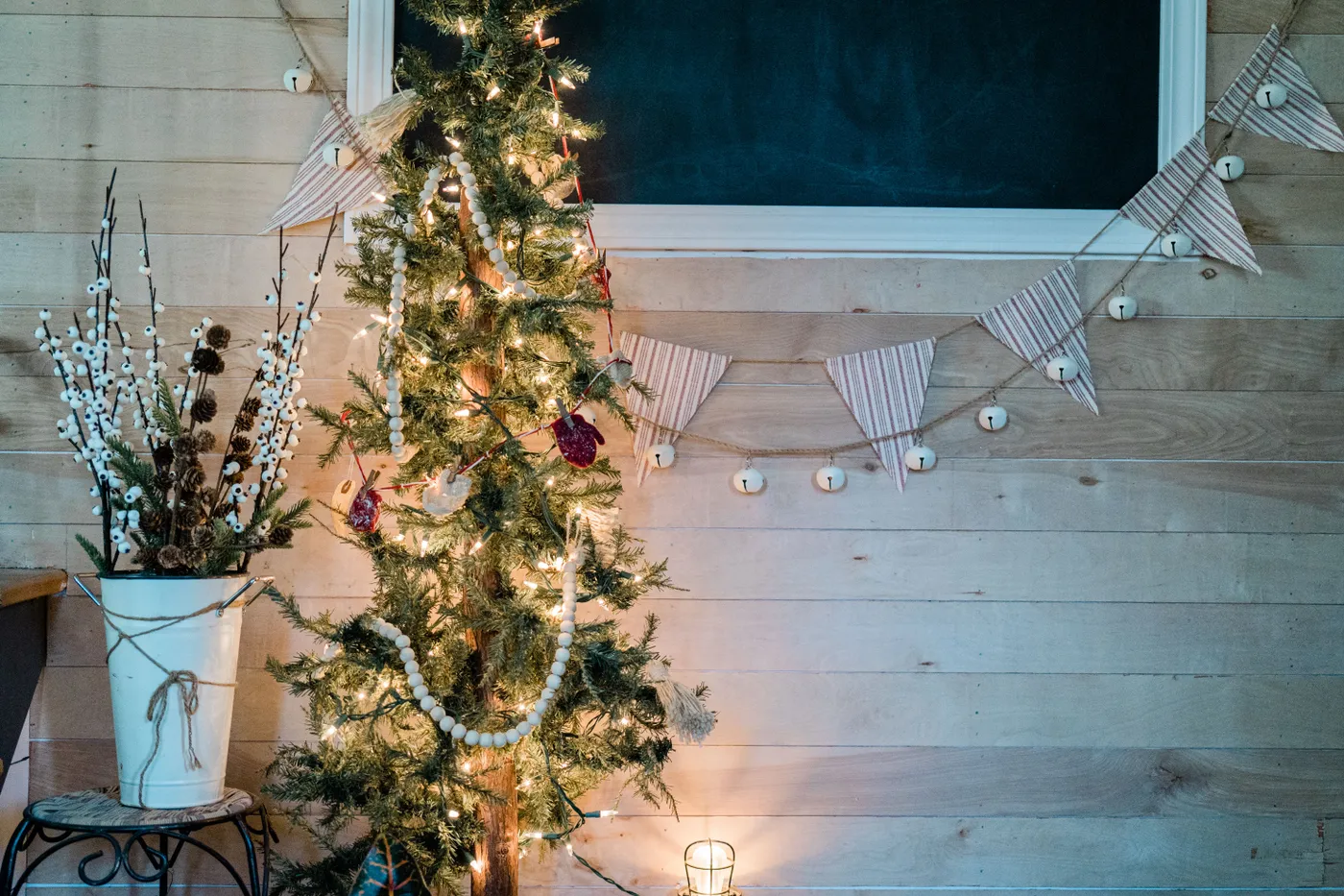 A cozy indoor scene featuring a decorated Christmas tree with lights, festive ornaments, and rustic home decor.