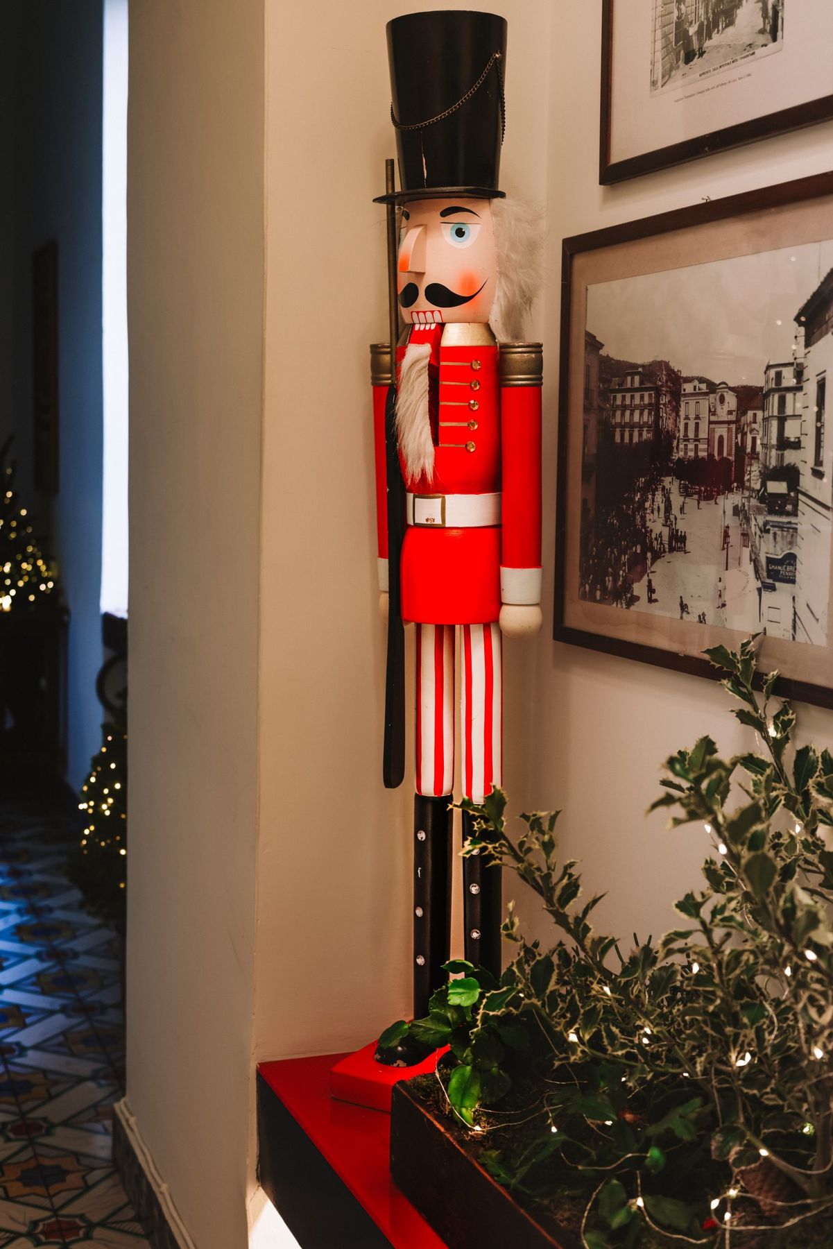 A decorative nutcracker soldier displayed in a warmly lit interior adorned with holiday decorations.