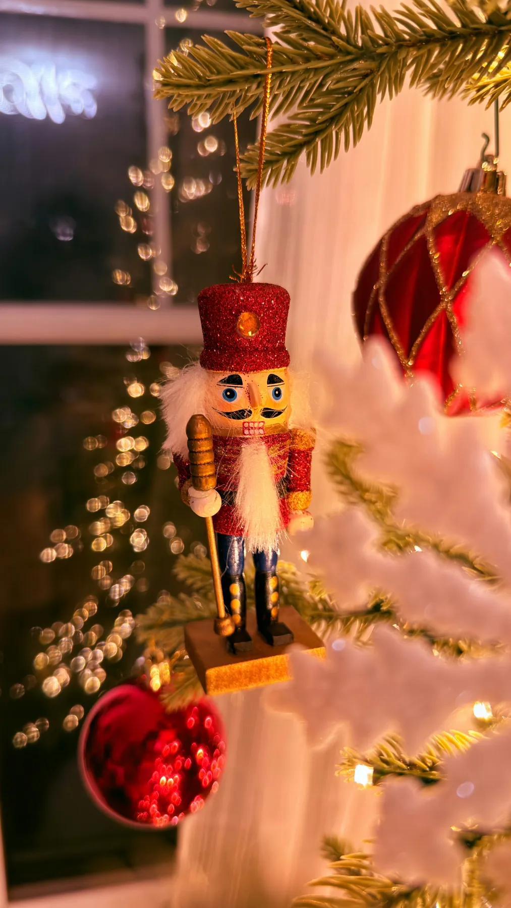 A nutcracker ornament hangs on a christmas tree - Free Photo on Unsplash