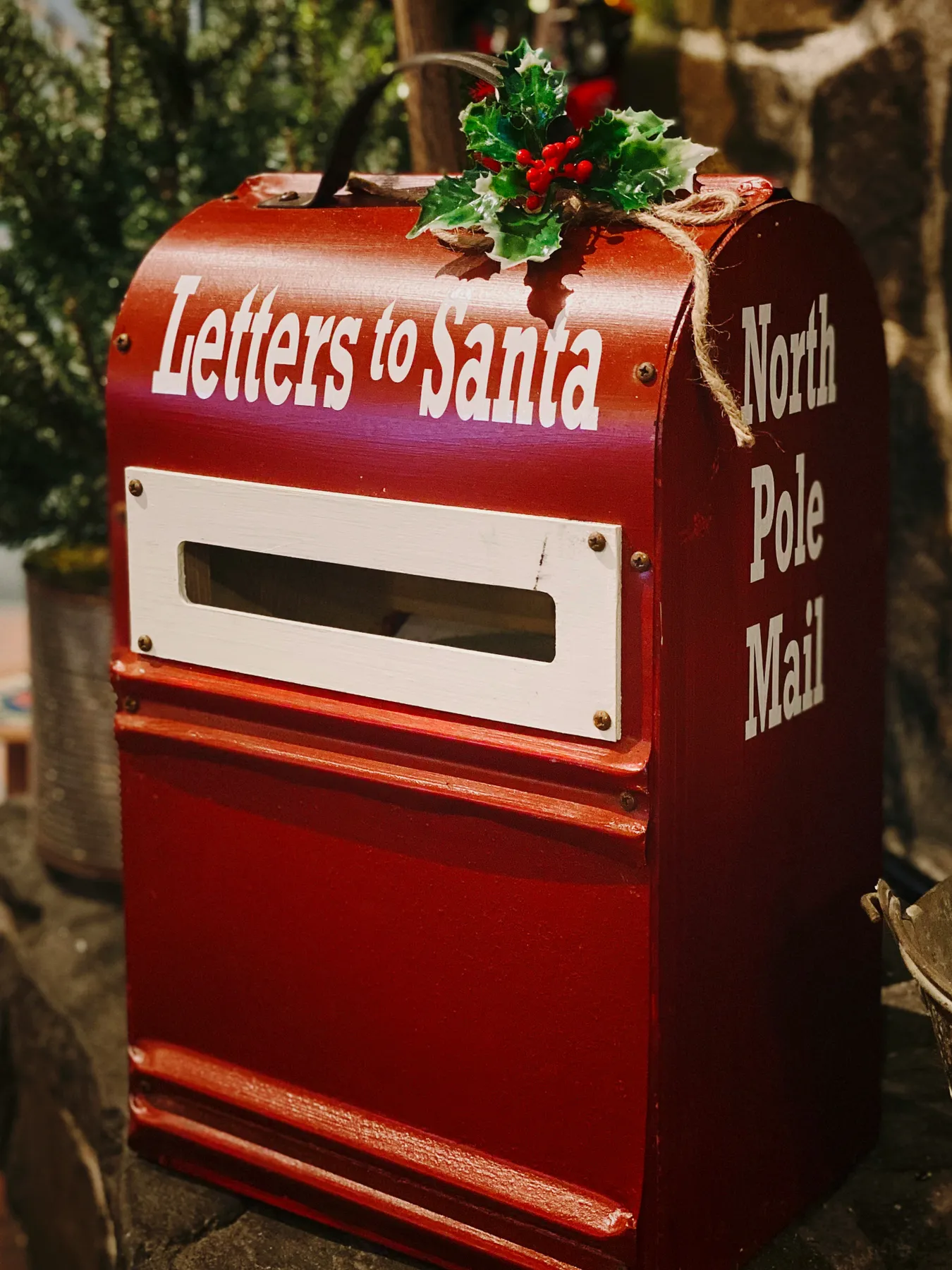 a red mailbox with a christmas wreath on top of it