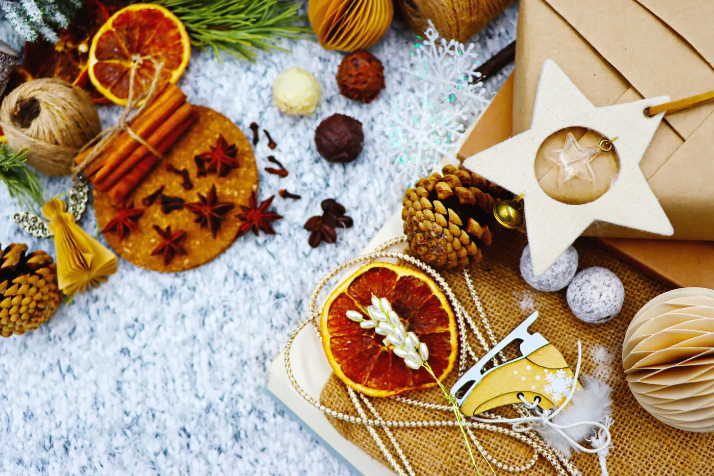 A rustic Christmas flat lay featuring natural materials, star anise, cinnamon, and recycled gifts.