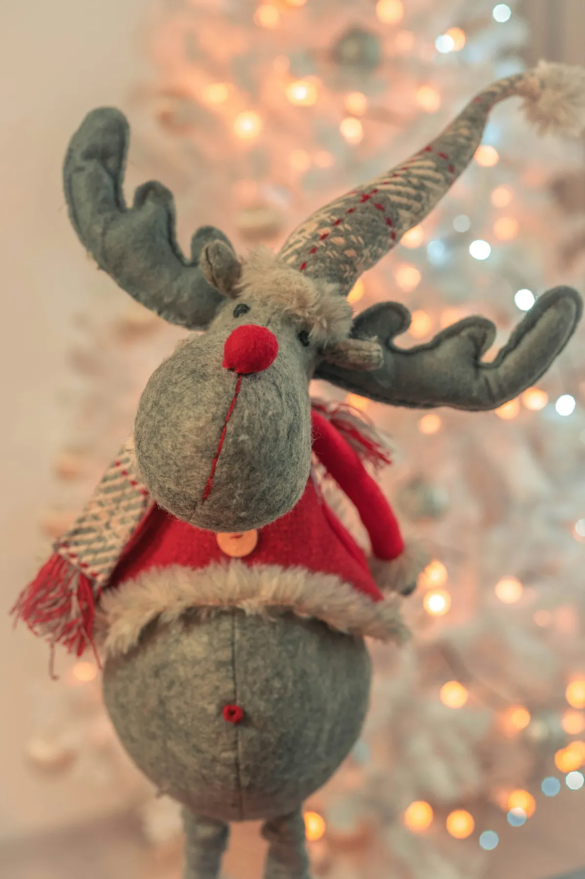 A stuffed moose wearing a santa hat and scarf