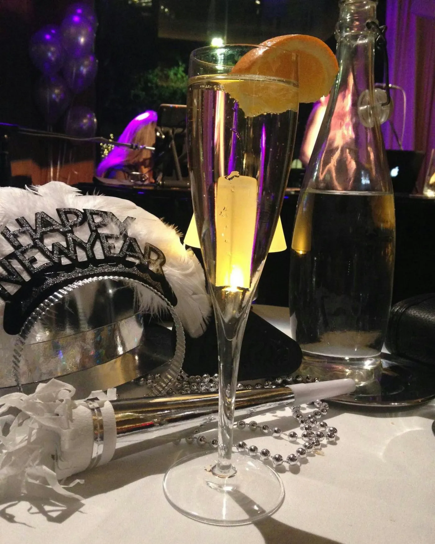 a table topped with a tall glass filled with liquid