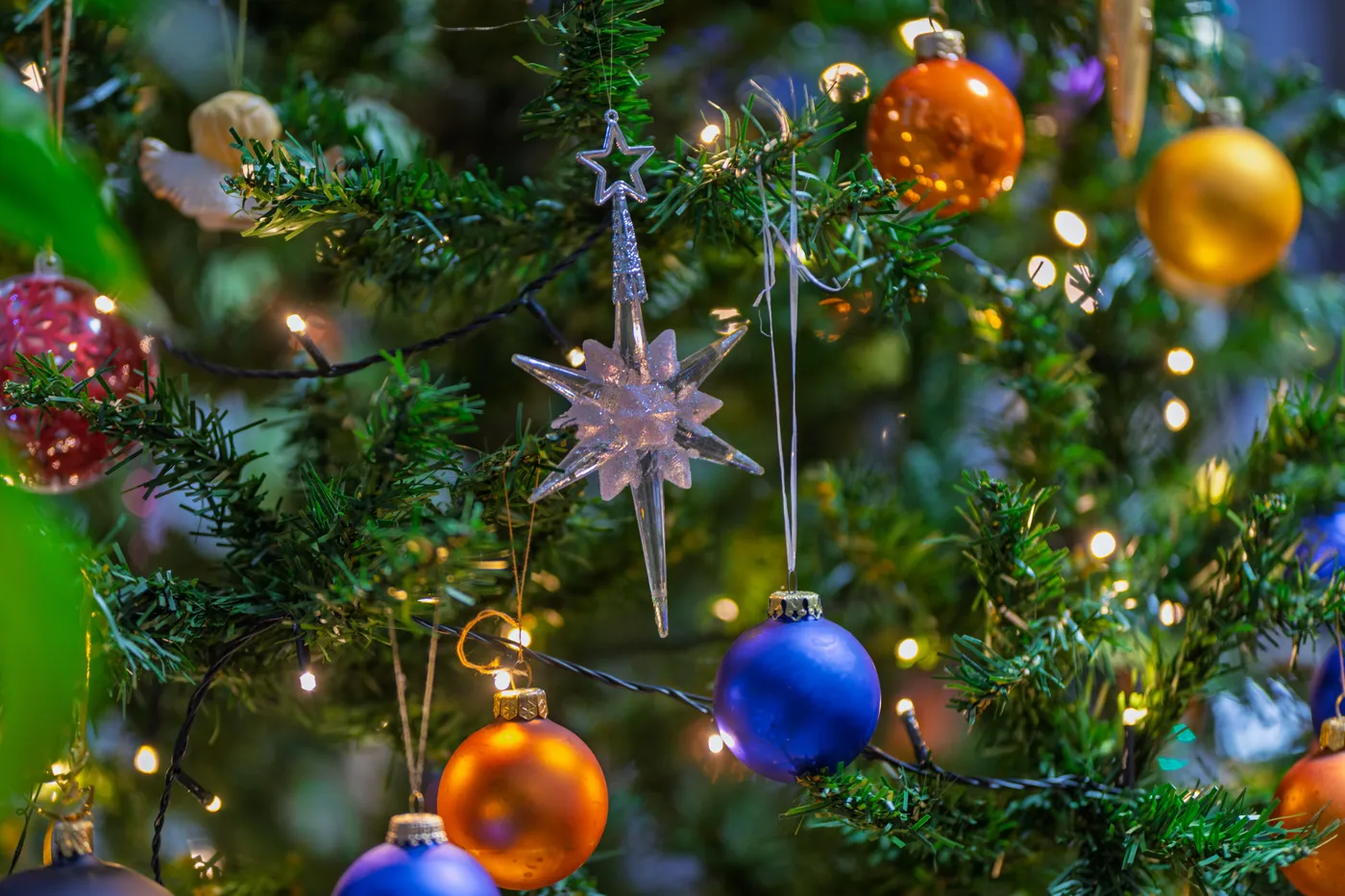 A vibrant Christmas tree adorned with colorful baubles and lights, capturing the festive spirit.