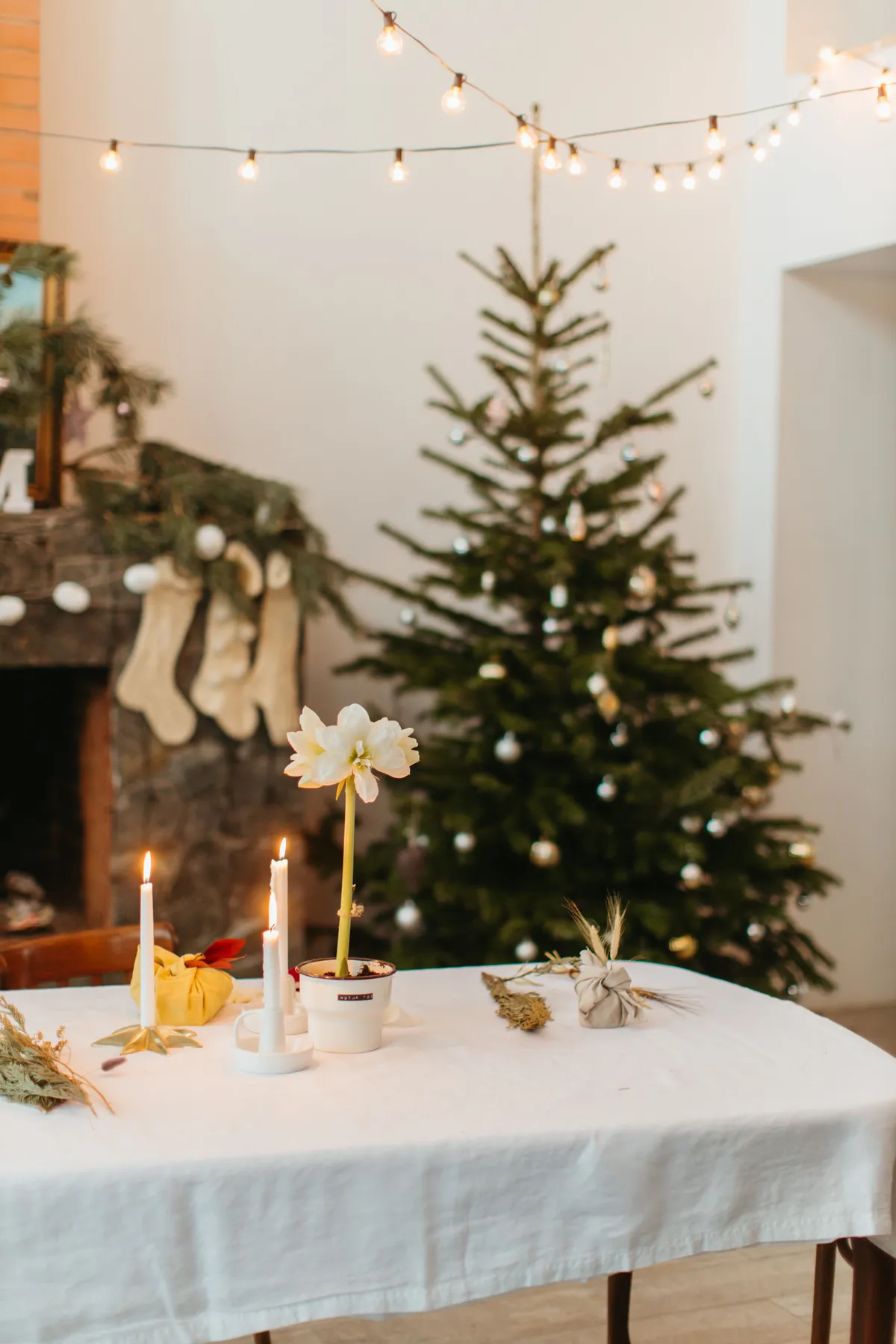 A warm and inviting Christmas living room with a decorated tree and festive table setting.