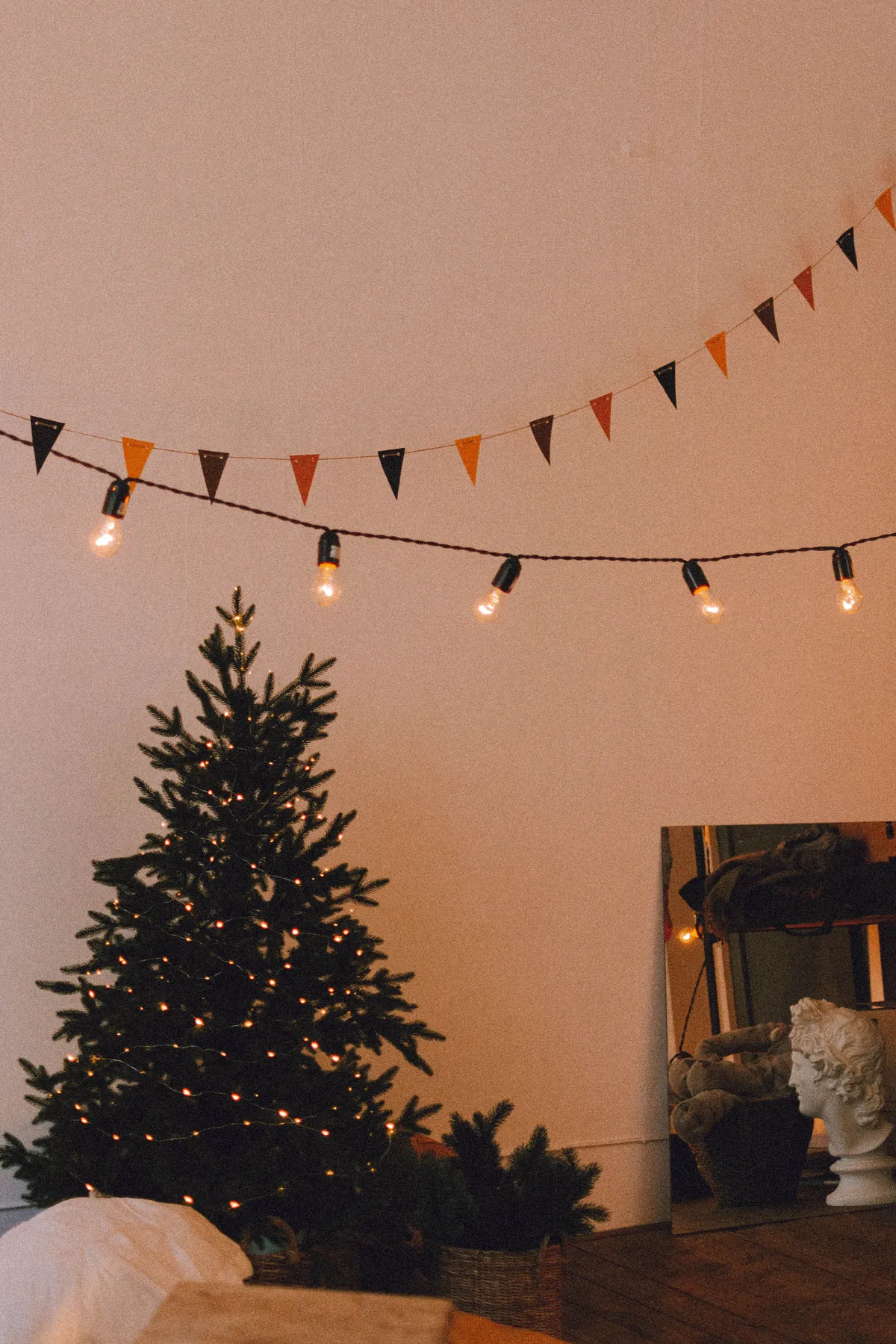 A warm and inviting Christmas tree with festive decorations in an indoor setting.