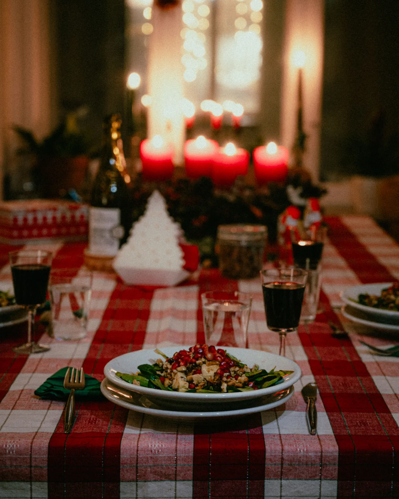A warm and inviting holiday dinner setting with red candles and festive decor.