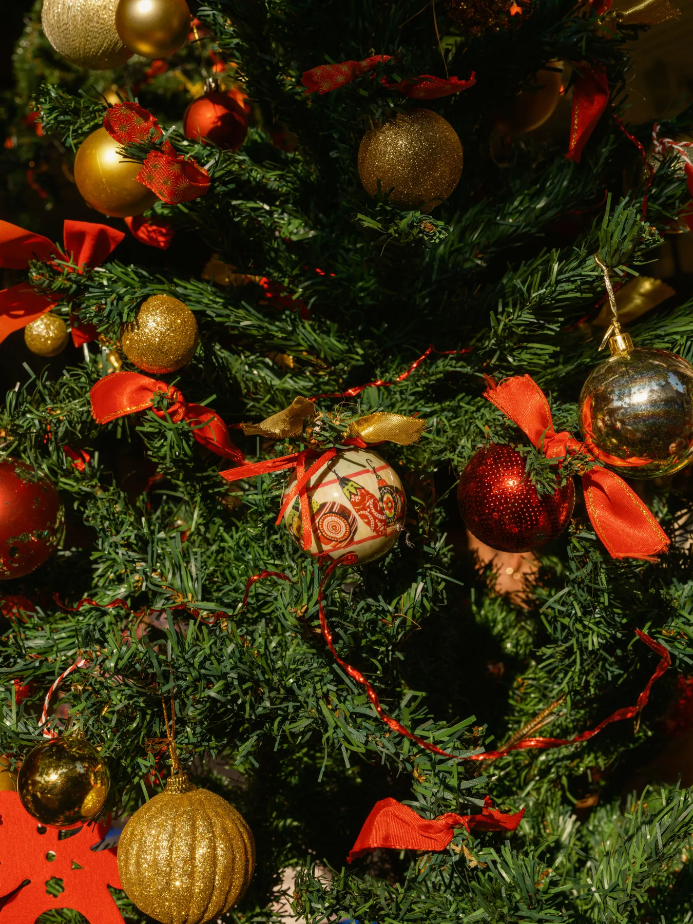 Beautifully decorated Christmas tree with red and gold baubles creating a festive atmosphere.