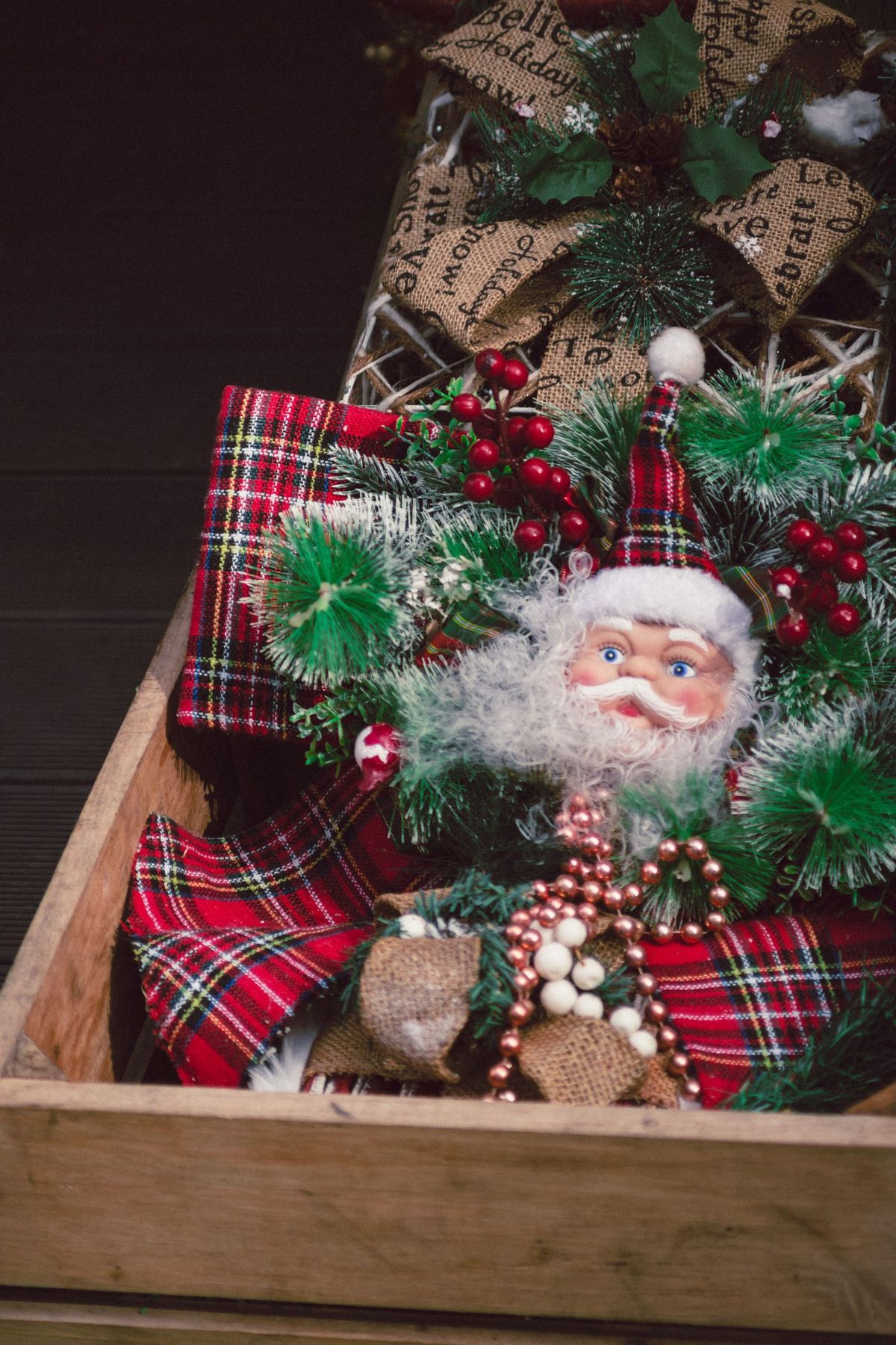 Charming Christmas decoration featuring Santa with festive greenery and ornaments.