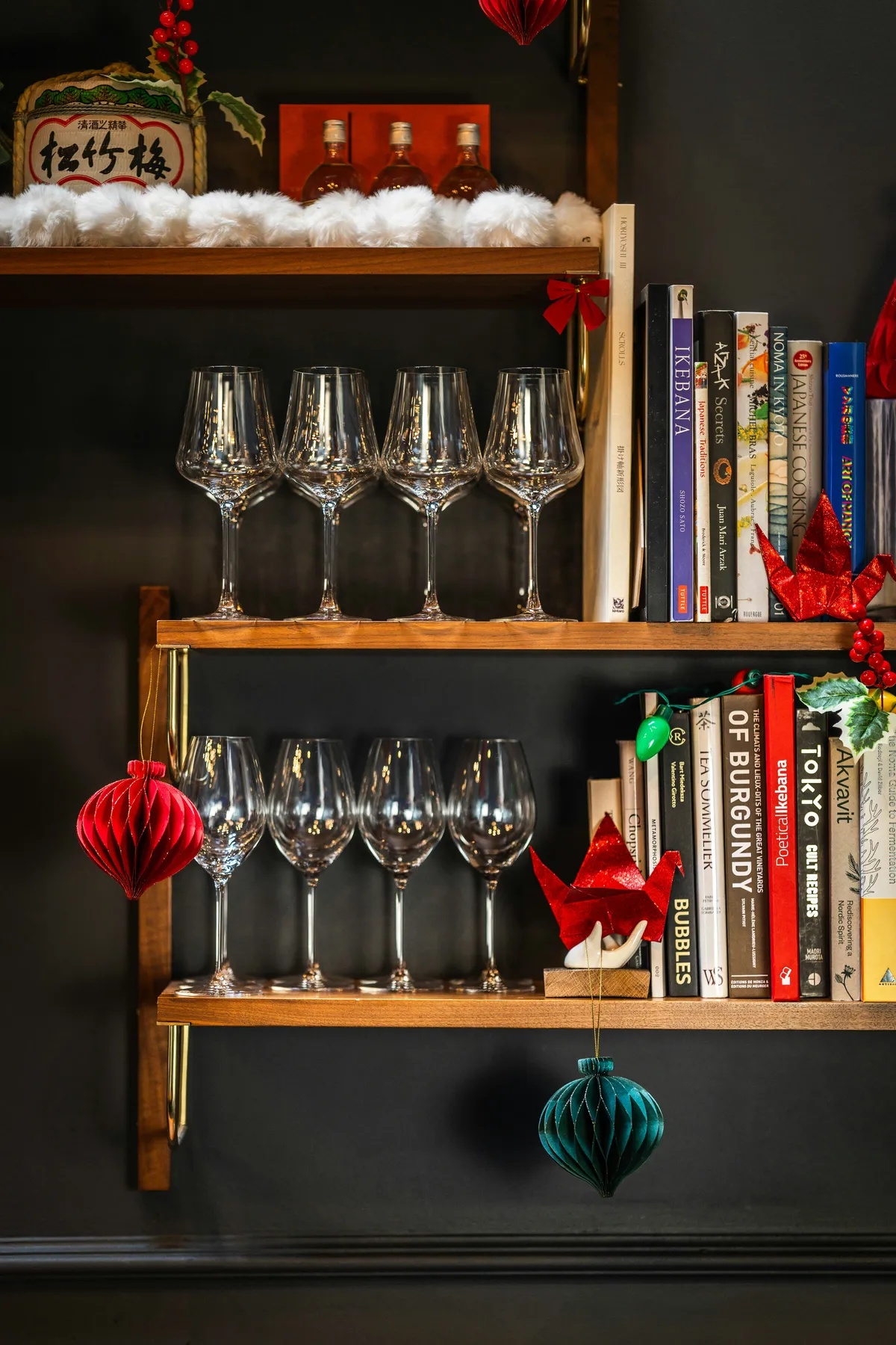 Christmas decorations on shelves with wine glasses and books
