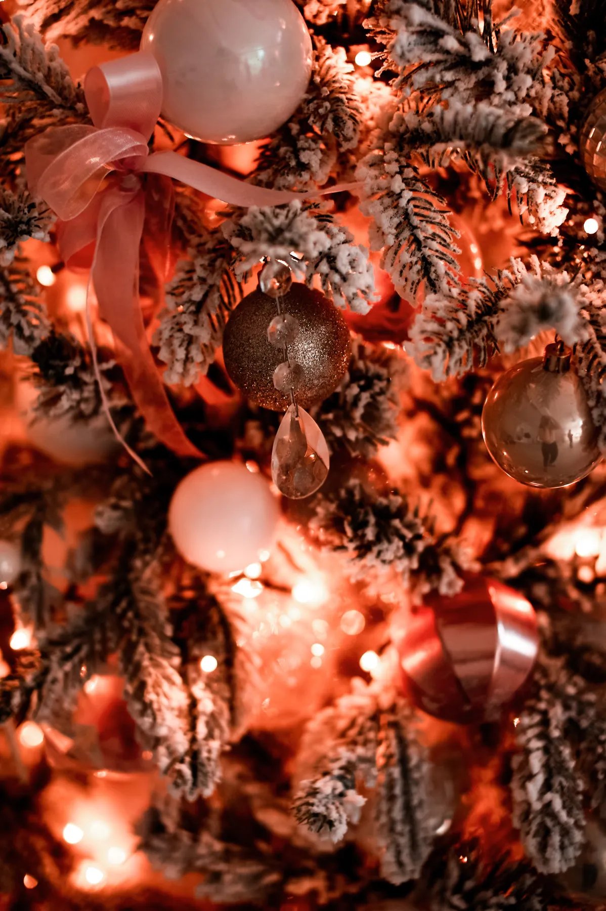 Close-up of a beautifully decorated Christmas tree with glittering ornaments and warm lights.