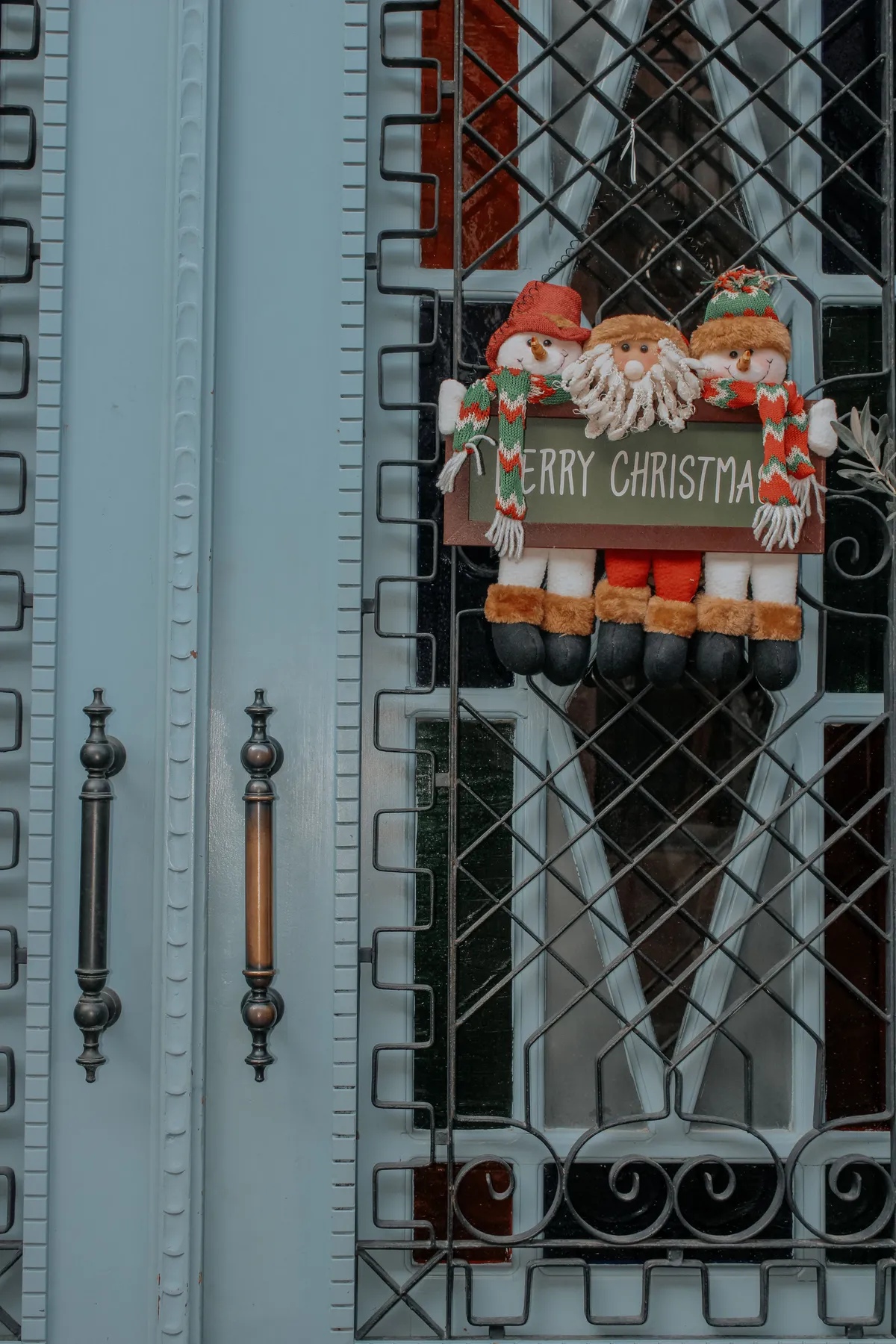 Close-up of a Christmas door with decorative Santa figures and a 'Merry Christmas' sign.