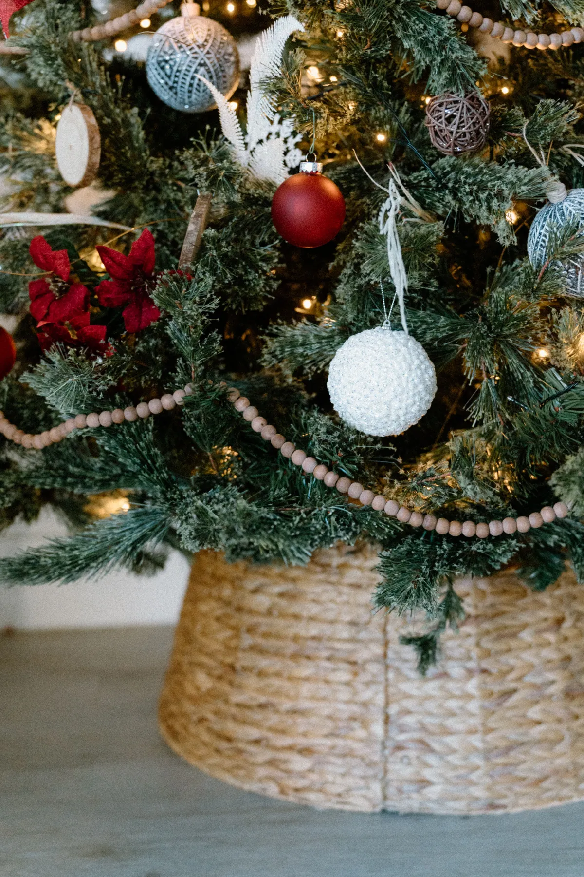 Close-up of a decorated Christmas tree base with ornaments and lights.