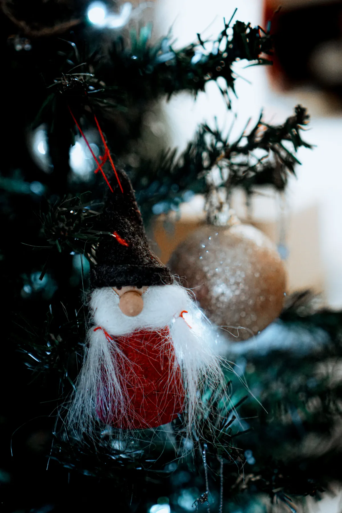 Close-up of a whimsical Santa Claus ornament on a Christmas tree in Lisbon, Portugal.