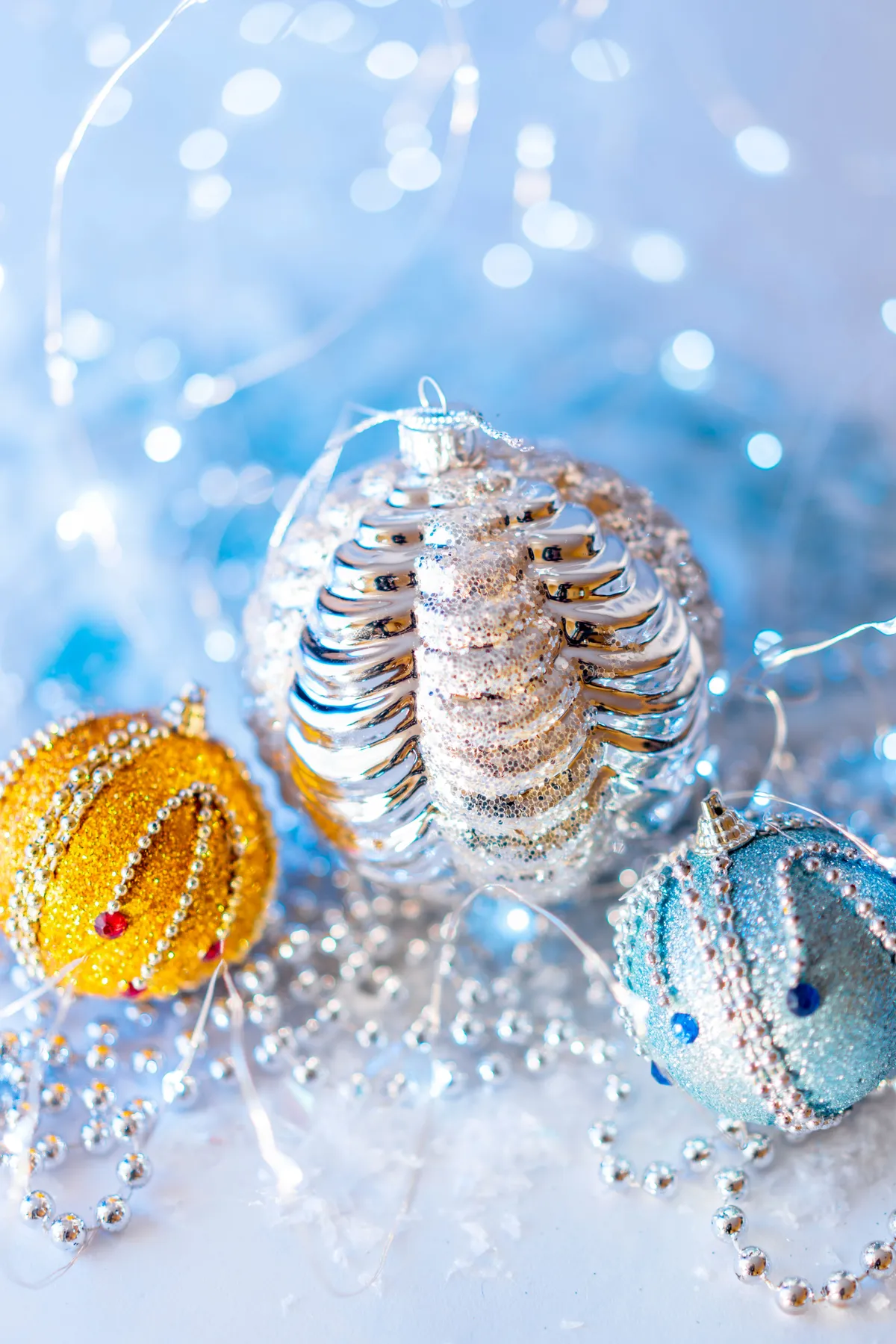 Close-up of glittery Christmas ornaments with tinsel and lights. Perfect for holiday decor inspiration.