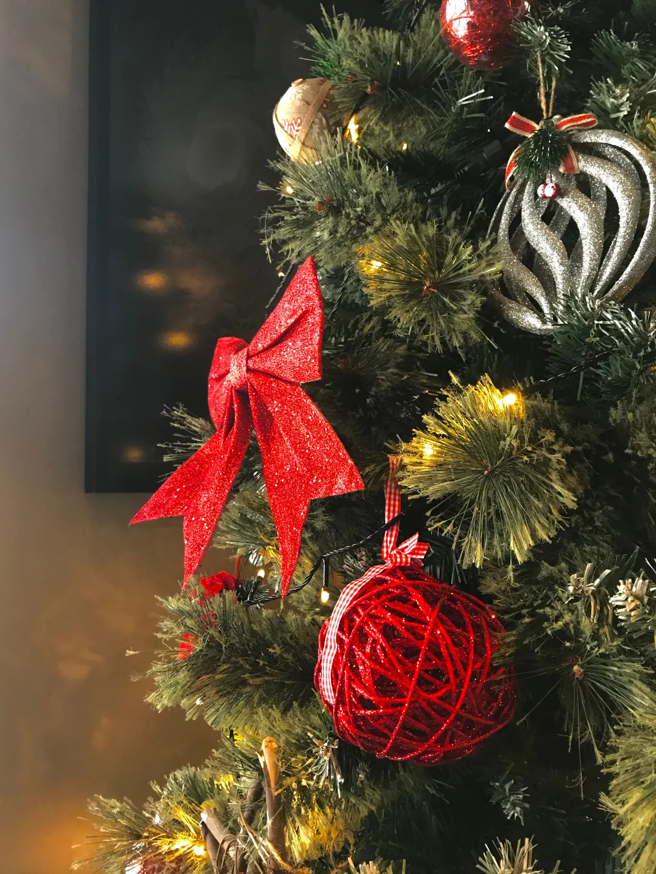 Close-up view of a Christmas tree decorated with red ornaments and bows, perfect for holiday ambiance.