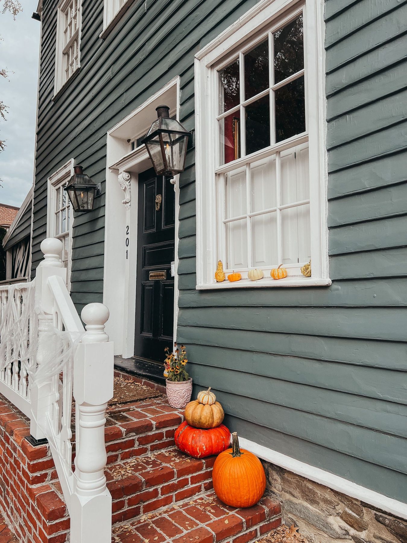 Cozy autumn porch scene with pumpkins, lanterns, and a classic doorway, capturing seasonal warmth.