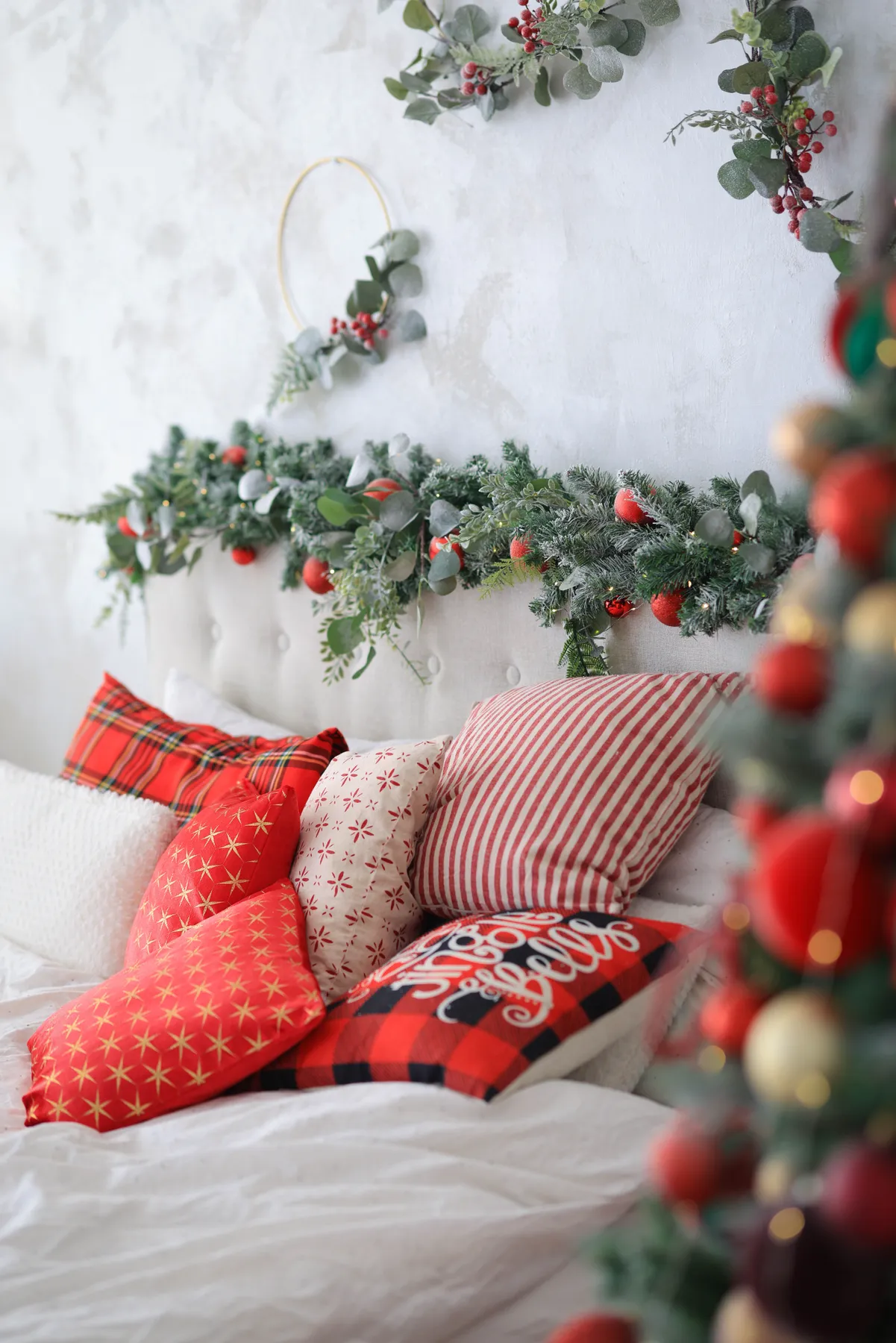 Cozy Christmas bedroom adorned with pillows and festive decorations.