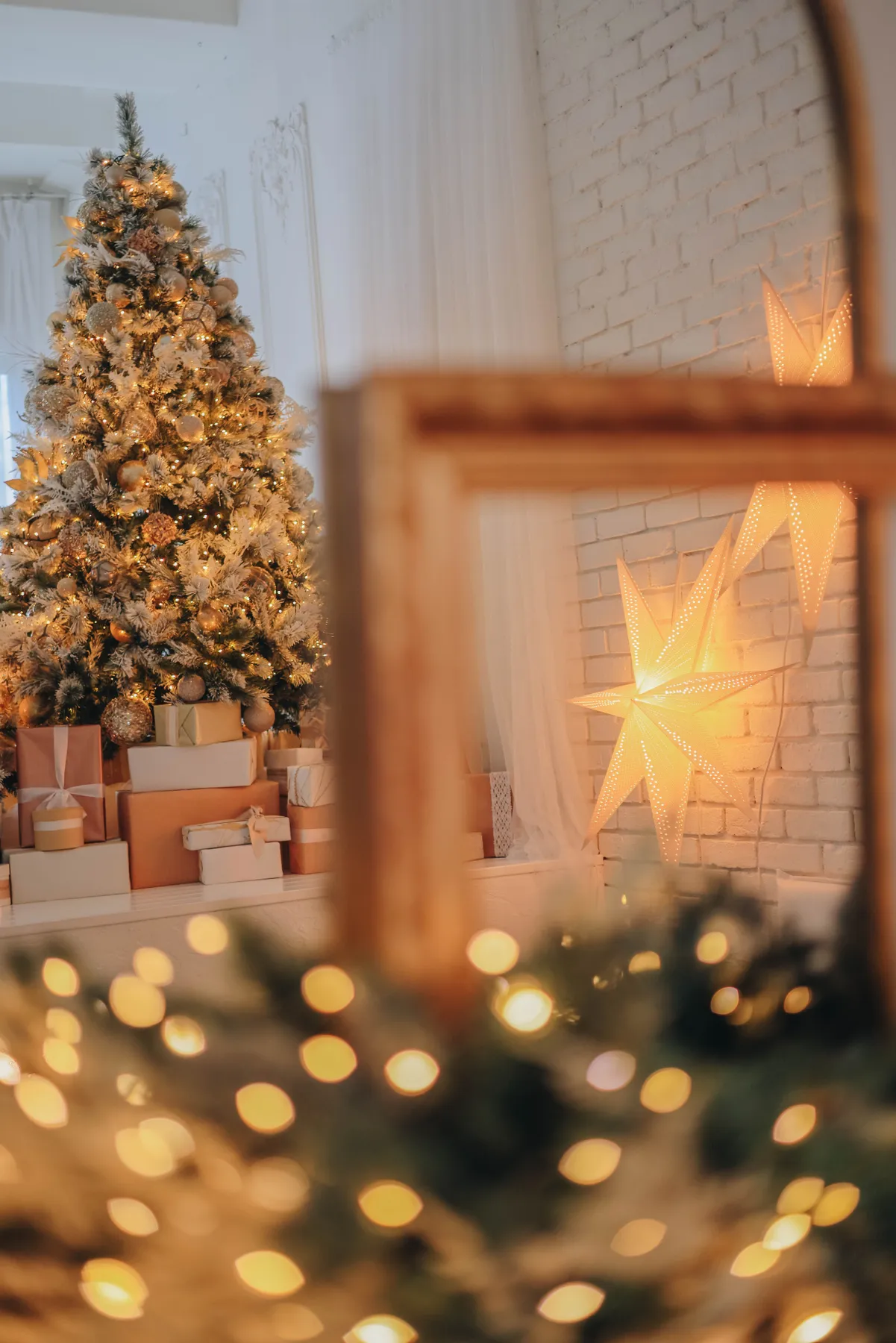 Cozy indoor Christmas scene with a decorated tree and glowing star lights.