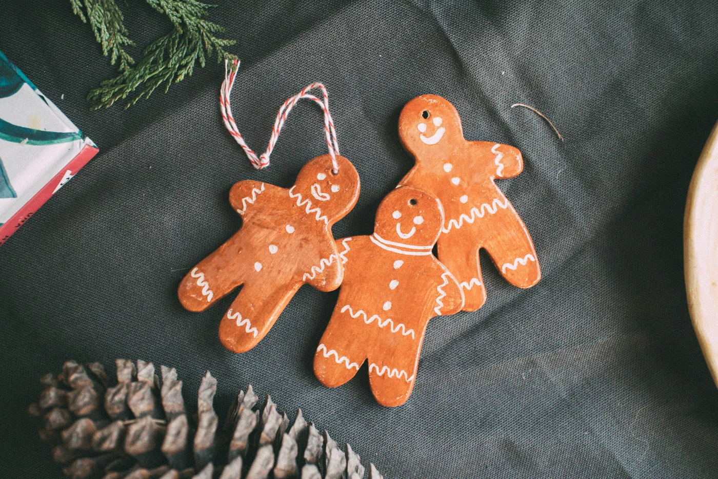 Cute gingerbread man ornaments on a festive cloth background, perfect for holiday decor.