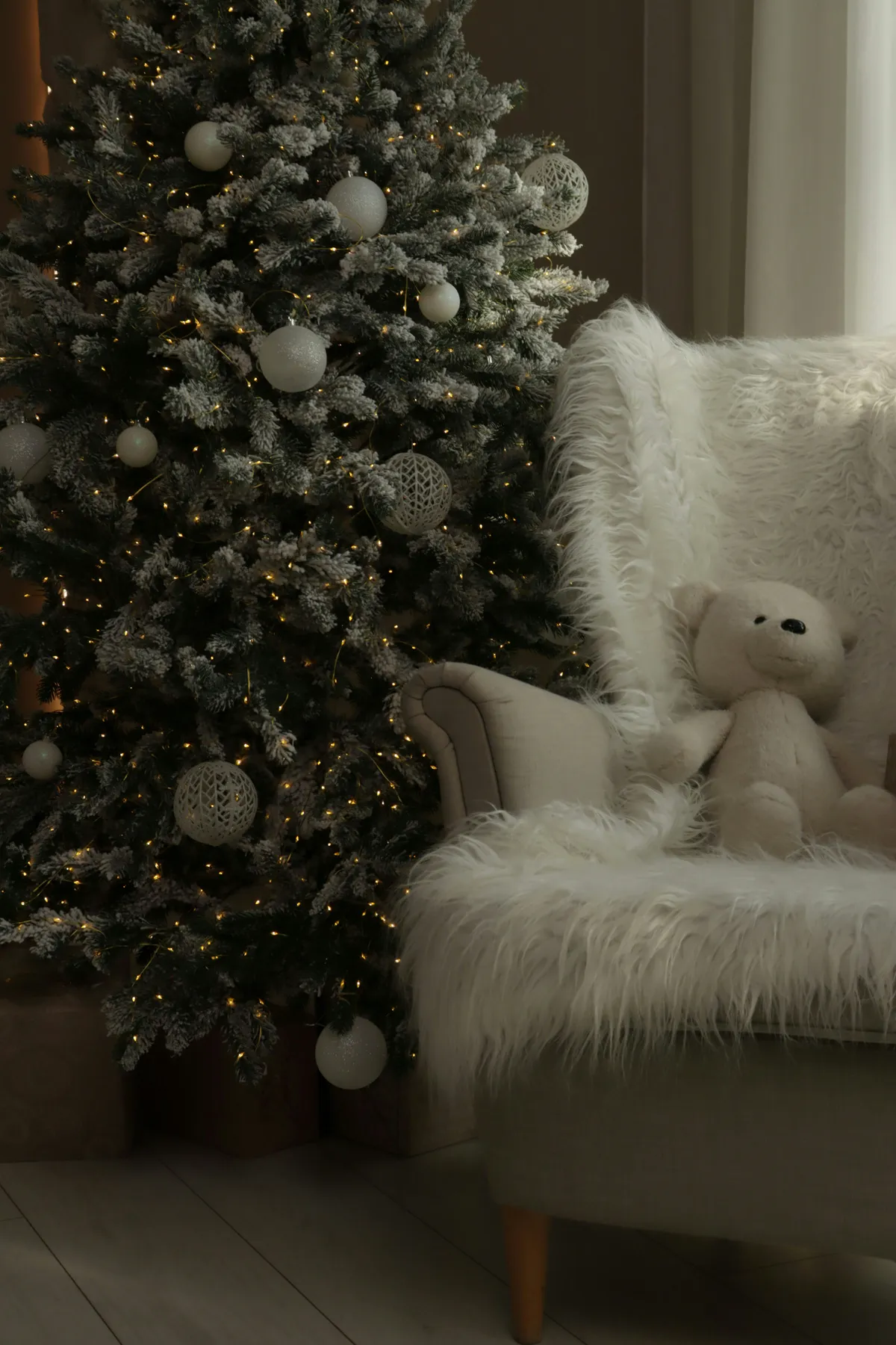 Decorated christmas tree and teddy bear on chair