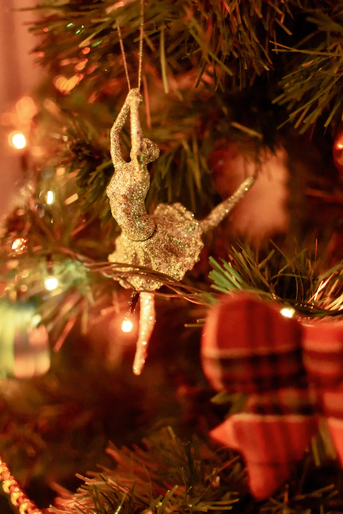 Elegant ballerina ornament adds sparkle to a festive Christmas tree with warm lights.