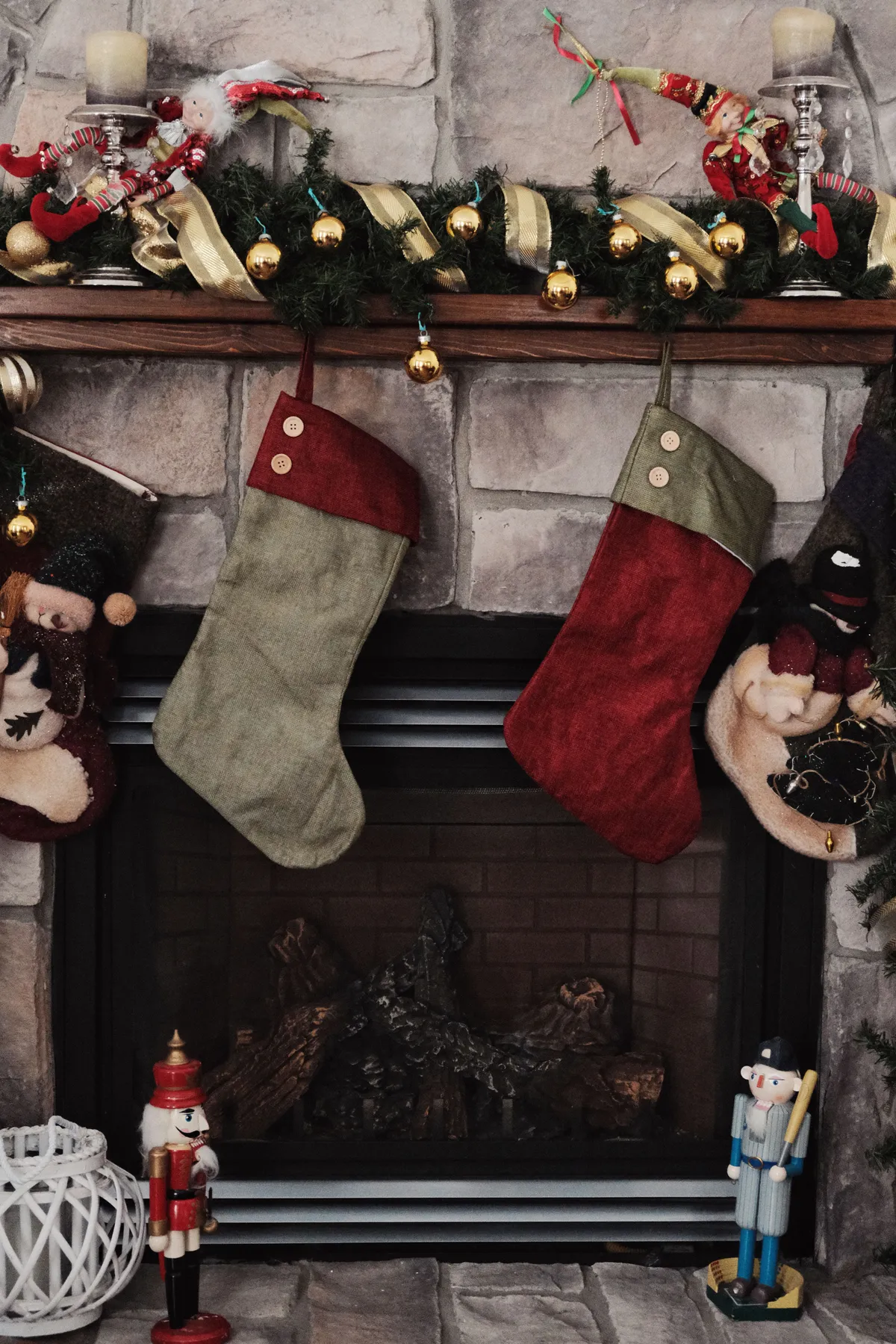 Festive Christmas stockings hanging on a decorated fireplace mantel.
