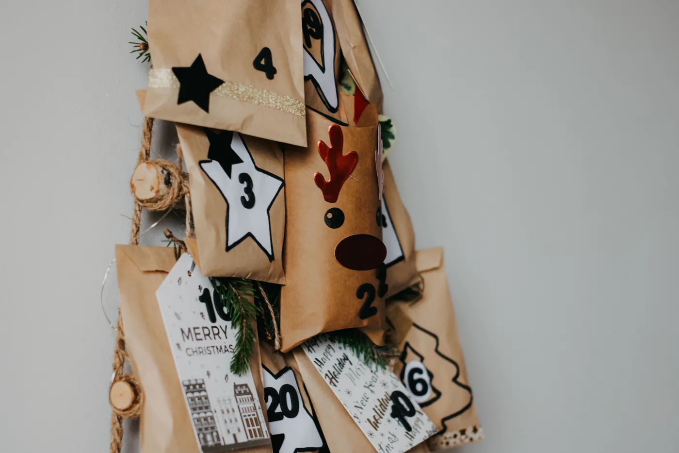 Handcrafted advent calendar with decorated paper bags and festive numbers for Christmas countdown.