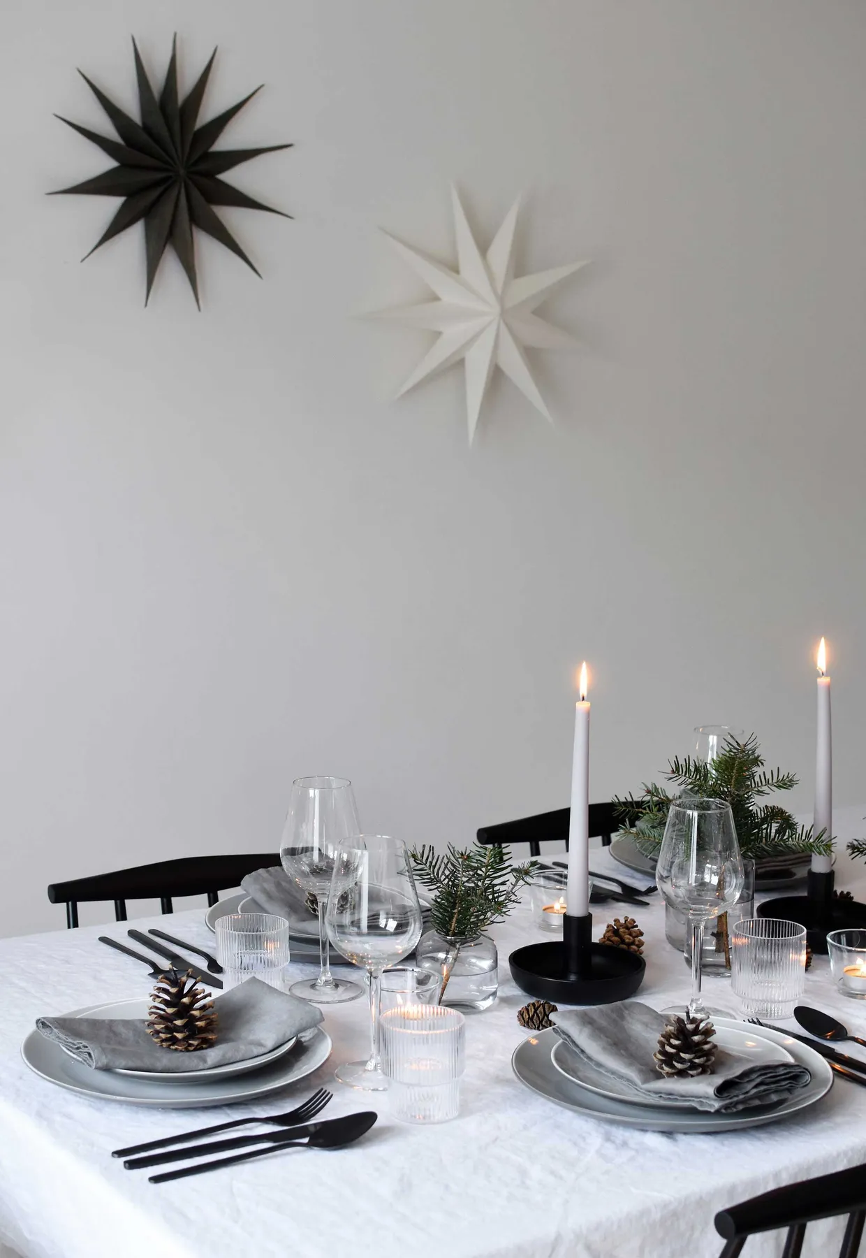 Minimalist Christmas table styling with fir, candles & pine cones |