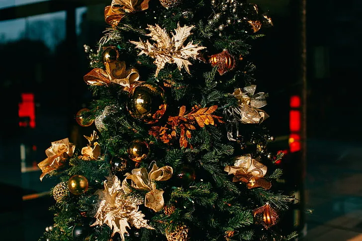 Royalty-Free photo: Green Christmas tree with gold flower decors | PickPik