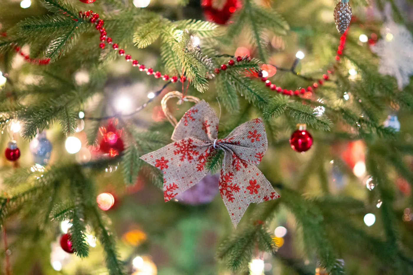 Soft felt ornaments and a red garland add handmade charm to a glowing Christmas tree.