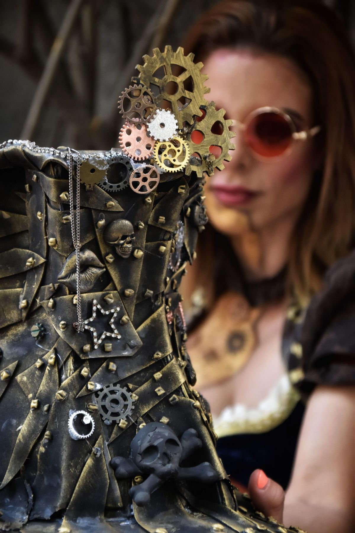 Steampunk-themed woman's portrait with gear-adorned boot, highlighting unique fashion.