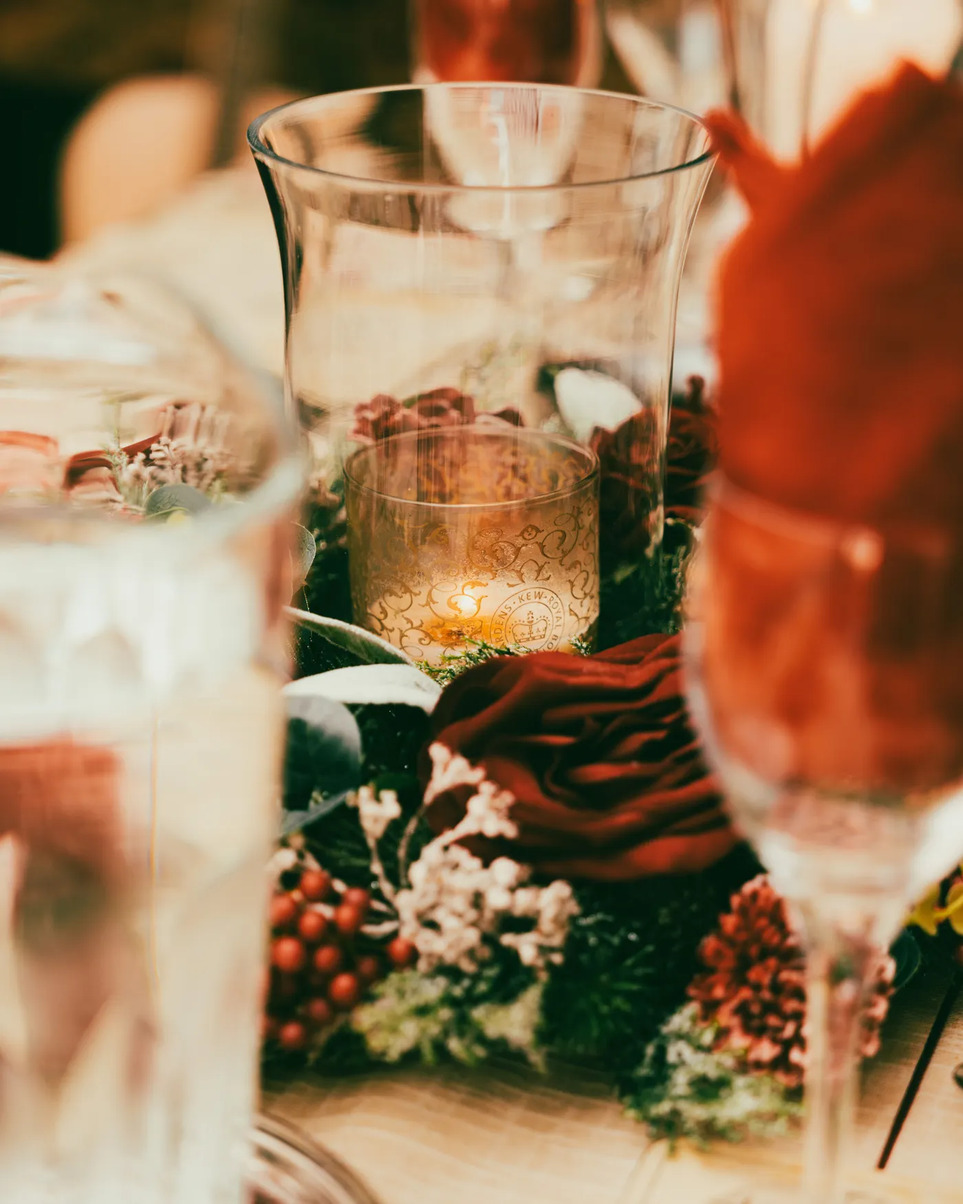 Warm and festive Christmas table setting with candlelight and Christmas ornaments.