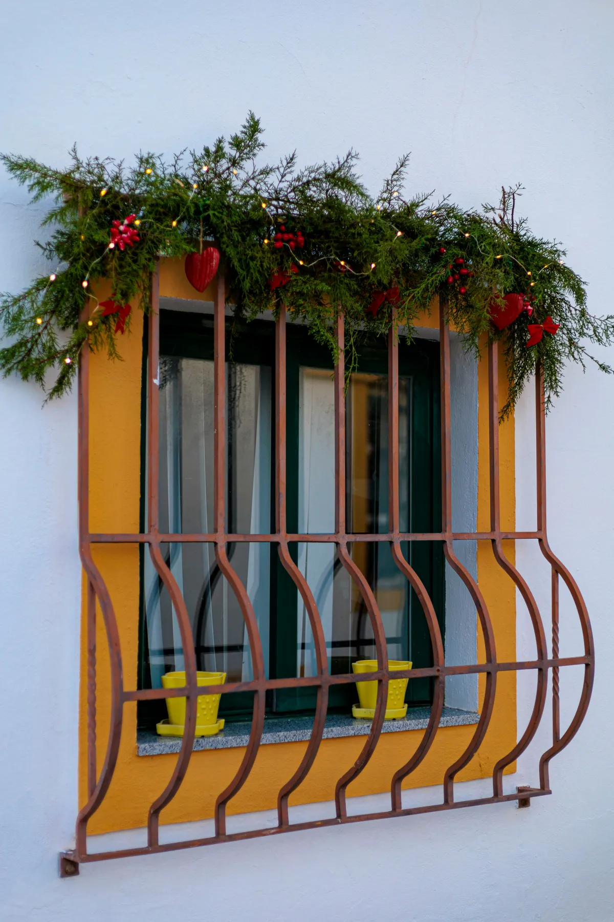 Window decorated with christmas greenery and lights