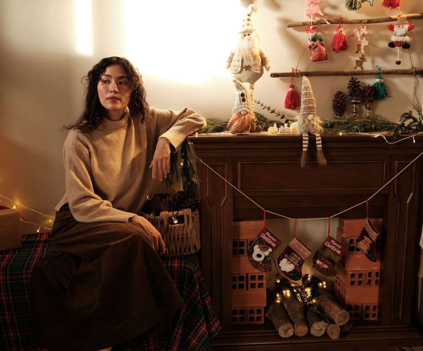 Woman sitting by a decorated fireplace at christmas